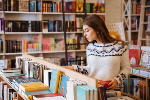 A woman browses the central shelves in a colourful bookstore