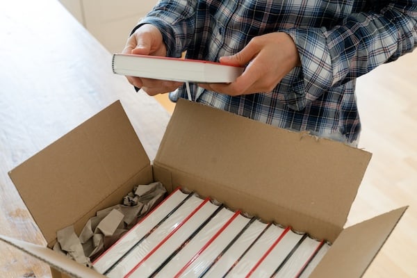 Someone opens a box of books.