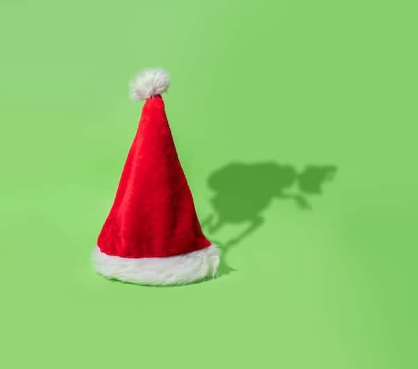 A Santa hat with a shadow shaped like the Grinch.