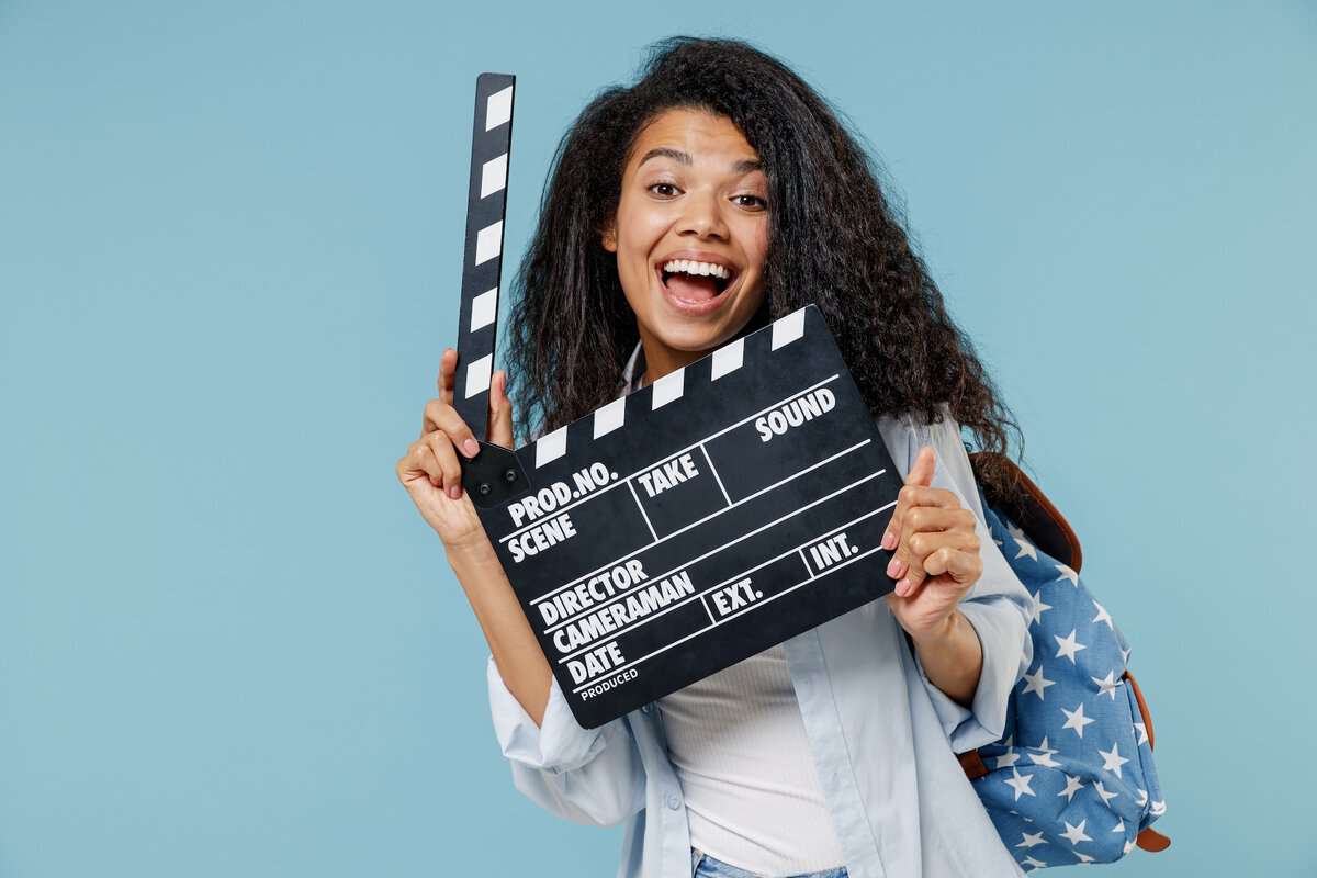 A woman poses with a film clapper board.