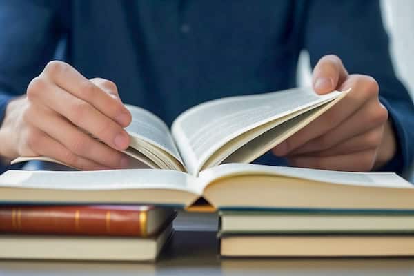 Hands holding the pages of a book open.