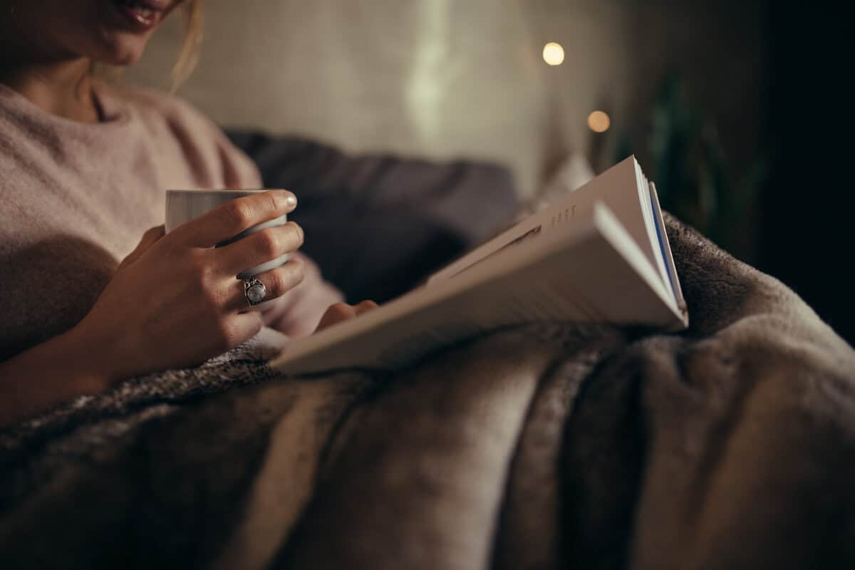 person in bed reading a book