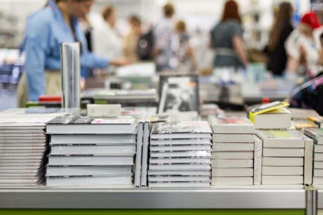 Several stacks of new books on a table.