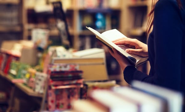 A person reading a book in a store.