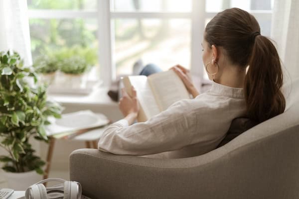 A person reading in a relaxed sitting chair